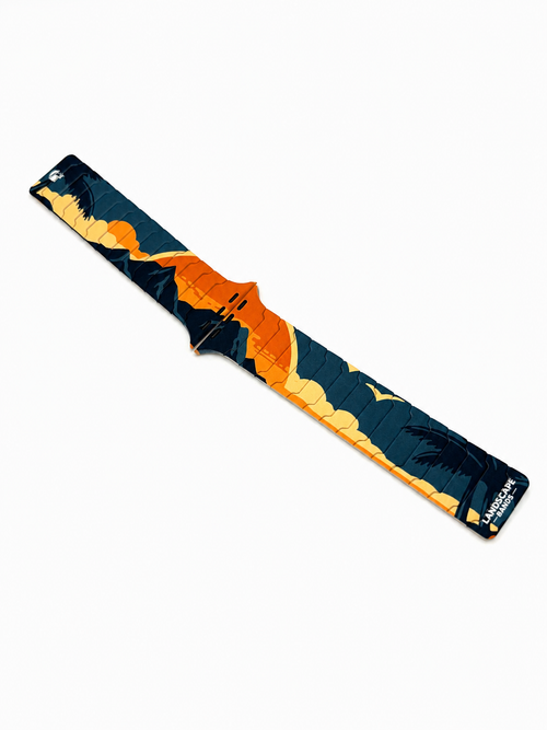 Angled view of the Tropic Dusk silicone magnetic Apple Watch band with detailed sunset landscape artwork.